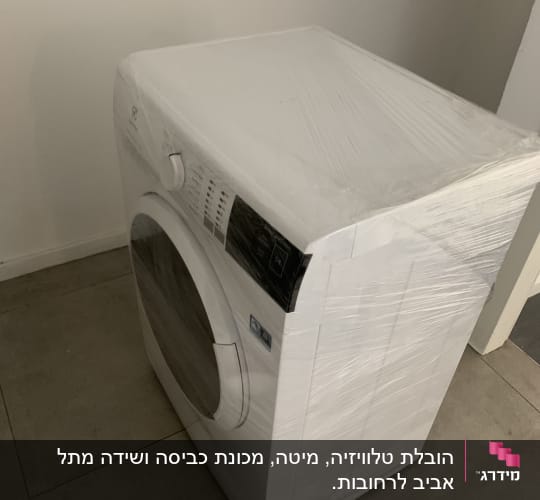 מכונת כביסה עטופה בניילון על רצפה אפורה